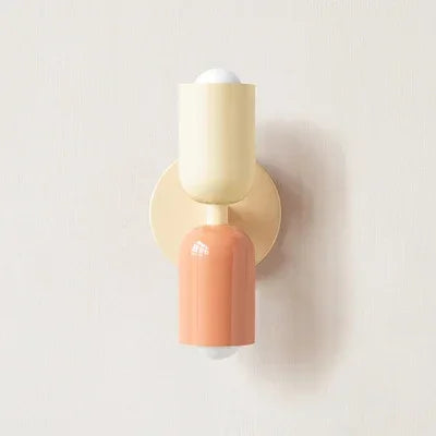 Retro wall lamp with a cream top shade, coral lower shade and cream round backplate