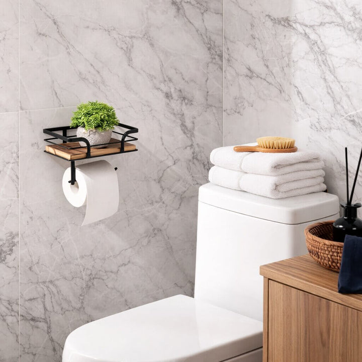 Toilet paper holder another view on a gray marble wall above a toilet, with a small green plant on the shelf.