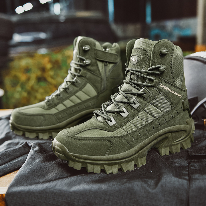 Pair of olive green lace-up boots resting on dark fabric, showing side zipper and lug soles 7