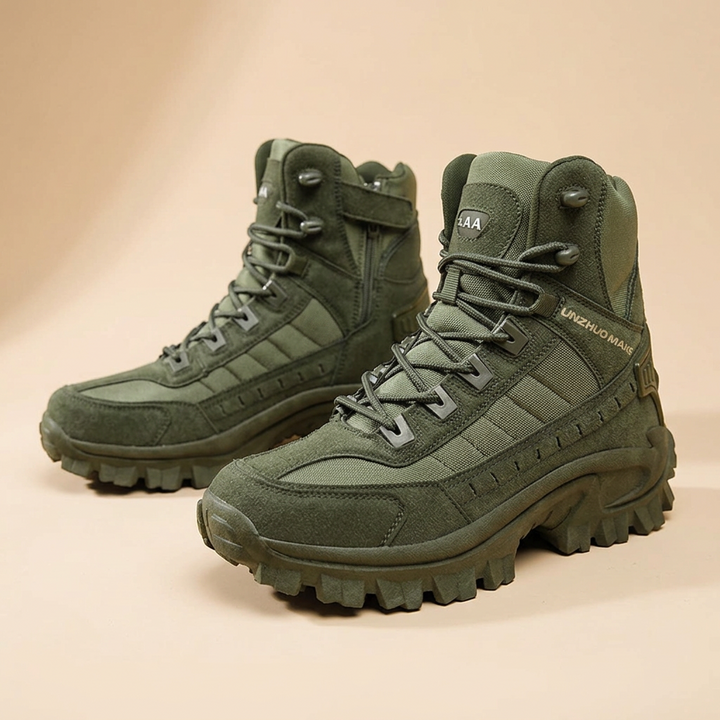 Pair of olive green boots on a beige backdrop, with a side zipper and strap visible on one 25
