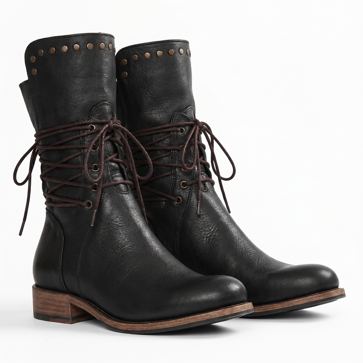 Pair of black leather boots with brass studs, criss-cross brown laces tied in bows and a wooden-look stacked heel.