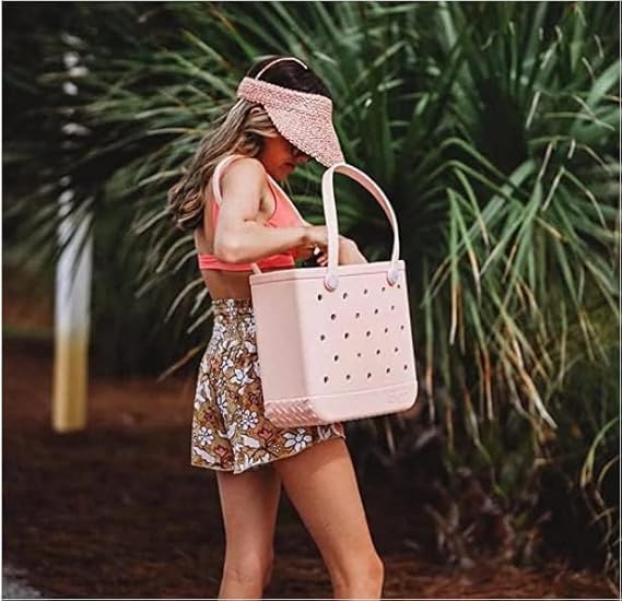 Light pink perforated tote carried outdoors by a woman.