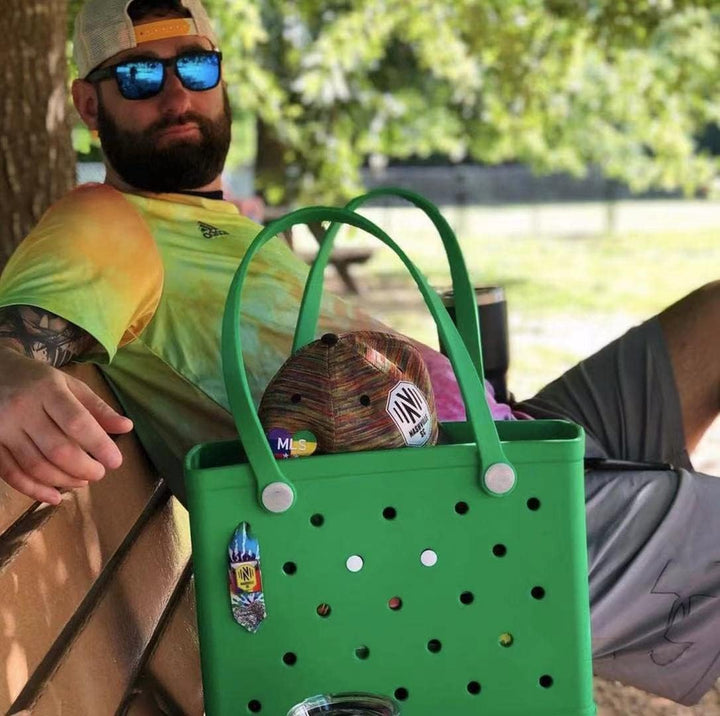 Green perforated tote detail with decorative charms.