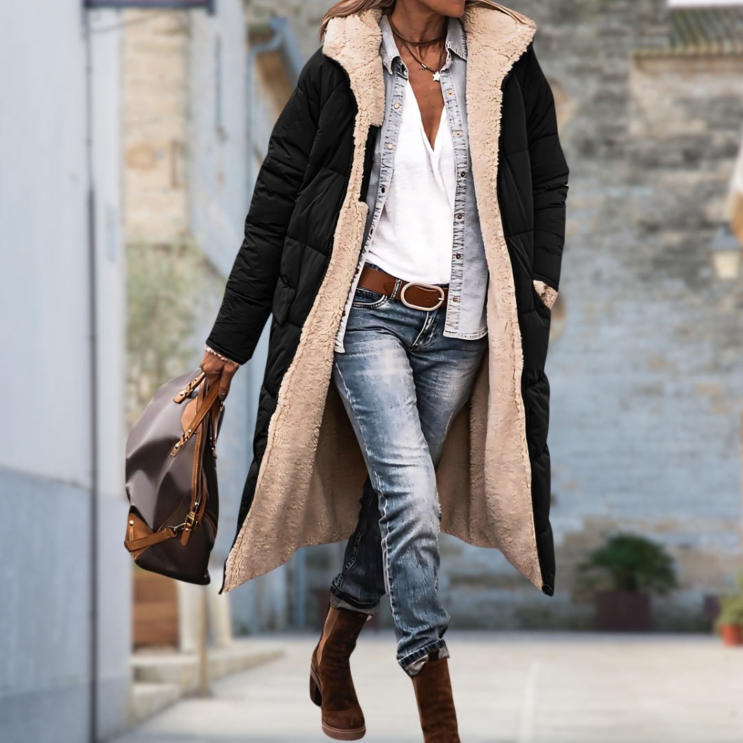 Woman walking down a street in the black quilted coat worn open over a denim shirt 4