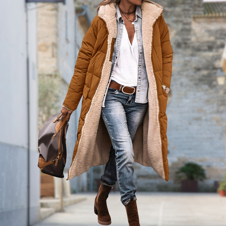 Camel brown quilted long coat with fleece lining worn open on a street, holding a leather handbag 9