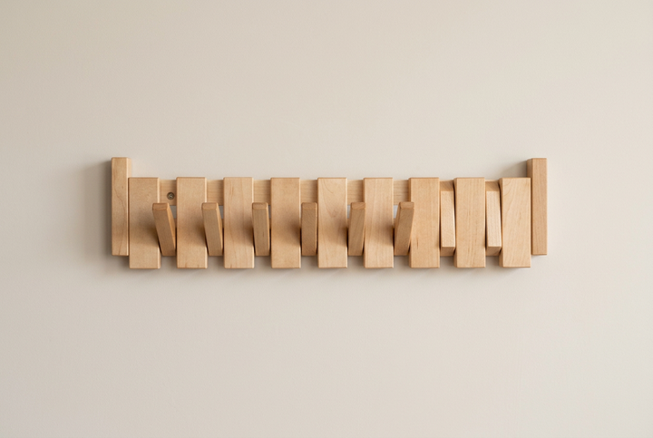 Light maple rack with a row of hooks folded out against a beige wall 13