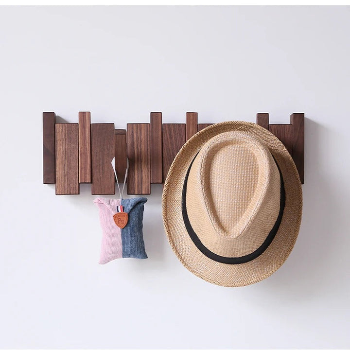 Dark walnut rack on a white wall with a straw fedora and a small pink and blue pouch hanging 4