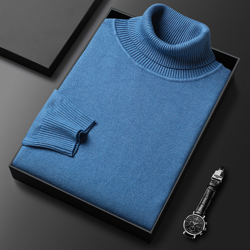 Men's cashmere blend turtleneck sweater in blue, folded in a black box beside a black-dial watch.