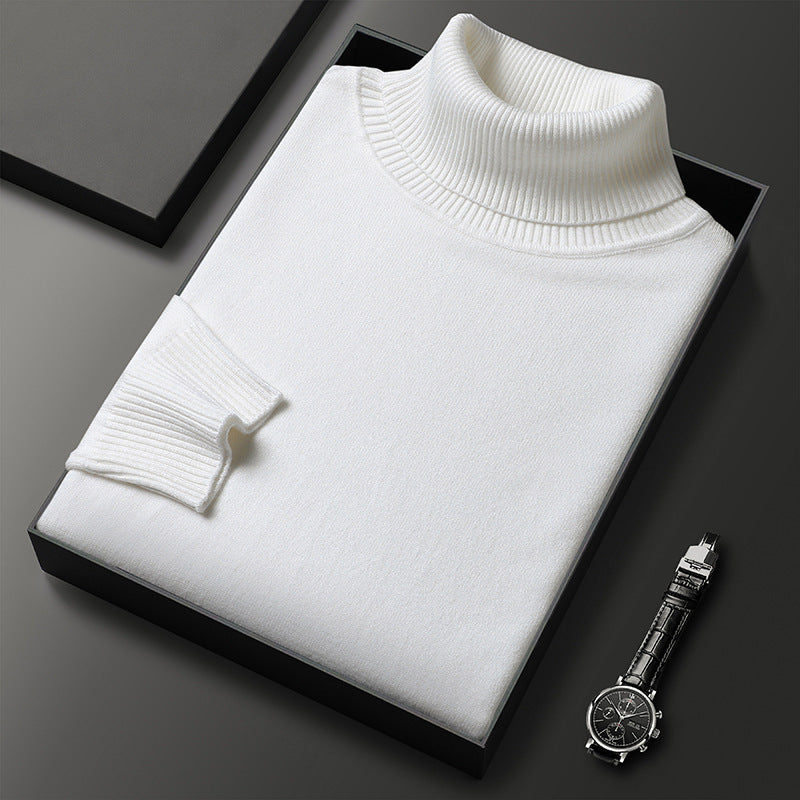 Men's cashmere blend turtleneck sweater in white, folded in a black box next to a black-dial watch.