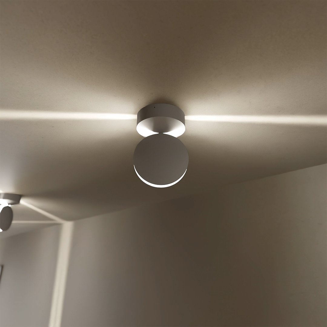 White LED wall sconce detail showing a round spotlight beam across the ceiling.