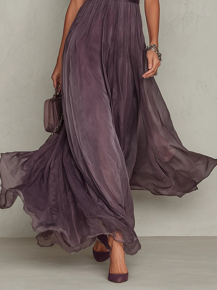 Women's purple maxi skirt close-up with flowing sheer fabric in motion.